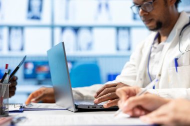 Genel pratisyen hekim, tıbbi kabinedeki bir toplantıda ekibine danıştıktan sonra bir tedavi planı yazıyor. Doktor hızlı iyileşme için bir çözüm öneriyor ve öneriyor. Kapat..