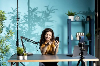 Streamer canlı yayın yapıyor, erkek arkadaşından gelen sulu mesajları okuyor, genç izleyicileri eğlendiriyor. Etkileyici cep telefonuyla sohbet okumak için heyecanlı, izleyicilerle konuşuyor.