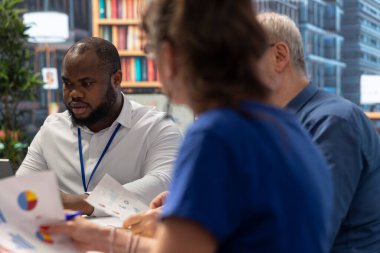 Olgun bir çift emeklilik planında finansal danışmanlık alıyor, yatırım fırsatları ve emeklilik planlarını tartışıyor. Yaşlı vatandaşlar, birikimlerini güvence altına almak için danışmanlarıyla görüştü..