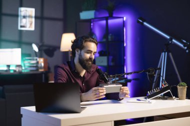 İnternetteki platformlar için Bluetooth portatif hoparlörünün teknoloji değerlendirmesini yaparken mutlu bir internet yıldızı. Gülümseyen etkili izleyicilerine müzik aleti sunuyor.