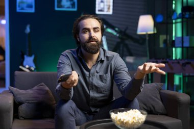 Yayın hizmetleri üzerine film seyrederken karakterlerle ters düşen, rahatlatıcı bir akşam geçiren bir adam. Sinema sahnesindeki mutsuz olay örgüsü izleyicileri tedirgin ediyor.