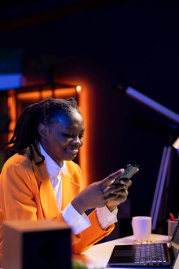 Dairesinde dinlenen, akıllı telefondan arkadaşlarına mesaj atan, boş vakitlerin tadını çıkaran bir kadın. Sosyal medya sitesinde arkadaşlarıyla konuşmak için ders çalışmaya ara veren gülümseyen genç cep telefonu kullanıyor