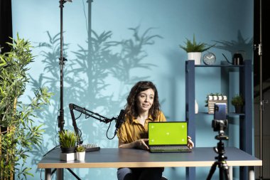 Gülümseyen teknoloji uzmanı, izole ekran dizüstü bilgisayar performansını değerlendiriyor, içerideki bileşenler hakkında konuşuyor. Çevrimiçi kanal için neşeli içerik oluşturucu tasarım defteri incelemesi