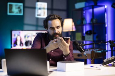 Teknoloji gurusu en son telefonu inceliyor, çevrimiçi olarak neon ışıklar stüdyosunda film çekiyor, profesyonel mikrofon kullanarak teknoloji vlog 'u çekiyor. Vlog yazarı piyasadaki en iyi akıllı telefonları sunar