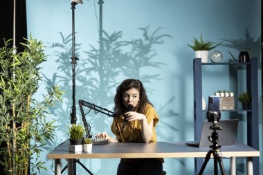 İçerik yaratıcısı profesyonel mikrofonu daha yakına yerleştiriyor, yaklaşan video için temiz ses kaydetmesini sağlıyor, akıllı telefonuyla tripodda çekim yapıyor. Vlog kaydedicisi ses seviyelerini kontrol ediyor, telefonla kaydediliyor