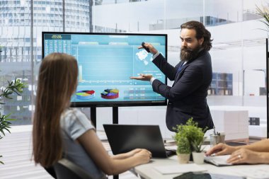 Finansal danışman, genç yetişkinlerin çeşitli yatırım portföylerini yönetmelerine yardımcı olmak için büyük ekrandaki çizelgeleri kullanıyor. Menajer, öğrenci kredisini ödemek için hisse senedi, tahvil ve diğer varlıkların karışımını teklif ediyor.