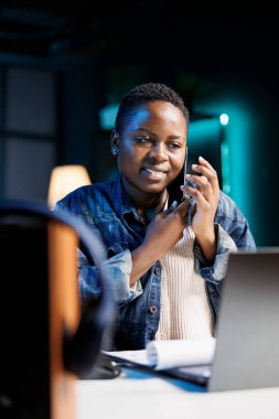 Ofisteki belgeleri incelerken, profesyonel siyahi kadın şahıs cep telefonundan konuşuyor. Telefon konuşmasında, Afrikalı Amerikalı öğrenci laptoptan aldığı notları meslektaşlarıyla karşılaştırıyor..