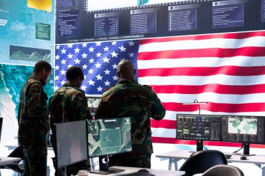 Amerikan askeri istihbarat subayları bir komuta merkezinde devlet sırlarını korumak için gözetim bilgilerini izliyorlar. Bir askeri harekat üssünde güvenliği sağlamak..