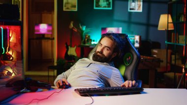 Man obsessed with playing videogames all day falling asleep at computer desk, crushing on floor from tiredness. Gamer suffering from gaming addiction feeling extremely sleepy, dropping from chair clipart