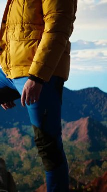 Dikey Video Huzurlu Gezgin dağa tırmanırken mutlu hissediyor, farkındalığın ve kararlılığın tadını çıkarıyor. Genç adam vahşi doğaya ve manzaraya tutkulu. Kamera A.