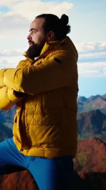 Dikey Video Heyecanlı Maceracı, kararlılık ve dayanıklılık ruhunu somutlaştırarak dağın zirvesine ulaşmasını kutluyor. Yürüyüşçü bir dağ silsilesinin panoramik manzarasının tadını çıkarıyor. Kamera A.