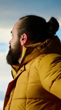 Dikey Video Erkek Kâşif, temiz hava ve manzaralı bir arka plan için dağın tepesine tırmanarak yüksek rakımlı yabanın yalnızlığını kucaklıyor. Doğadaki farkındalık ve rahatlama. Kamera.