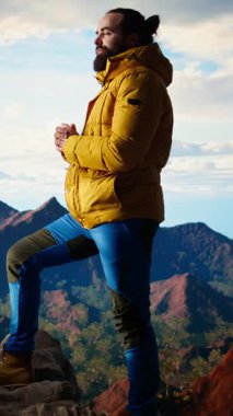 Dikey Video Gezgini yüksek rakımlı yabanda tek başına duruyor nefes kesici manzaraya hayran kalıyor, temiz havanın ve çarpıcı dağ manzarasının tadını çıkarıyor. Huzurlu atmosfer farkındalığa ilham verir.