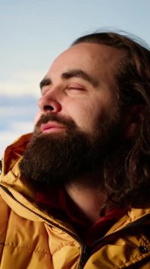 Dikey Video Genç Yetişkin Yürüyüşçüleri çadırı ile dağın tepesinde kamp kuruyor. Aşırı soğuk rüzgarlarla savaşıyor. Rüzgarlı ve güzel manzaralı bir yer. Nefes kesici kamp alanı, seyahat tutkusu. Kamera.