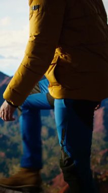 Dikey Görüntü Yalnız Gezgini dağın zirvesinde dikiliyor. Sersemletici tepe manzarası, bulutlar ve sonsuz gökyüzü, maceraperest. Nefes kesici manzara kararlılığı sembolize eder. Kamera A.