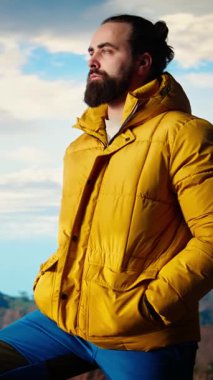 Dikey Video Gururlu mutlu kâşif dağ zirvesine tırmanmaktan memnuniyet duyuyor, farkındalığın ve kararlılığın tadını çıkarıyor. Genç yetişkin vahşi doğa ve destansı manzara hakkında tutkulu oluyor. Kamera A.