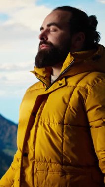 Dikey Video Maceracısı, doğanın farkındalığından ve zihinsel berraklığından keyif alarak dağın zirvesinde kararlılık ve dayanıklılık gösteriyor. Huzurlu bir gezgin aşırı yürüyüş yapıyor. Kamera A.