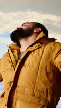 Dikey Videolu Neşeli Yürüyüşçü dağın zirvesinde dans ve tezahürat yaparak zafer kazandı. Huzurlu atmosferde ve temiz havada ıslandı. Yükselen tepe ve bulutların manzarasının tadını çıkarıyorum. Kamera B.