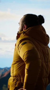 Dikey Video Genç Gezgini yüksek rakımlı yabanın, çarpıcı manzaranın ve huzurlu çevrenin tadını çıkarıyor. Doğa aşığı ve dağın zirvesine tırmanmaktan mutlu. Kamera B.