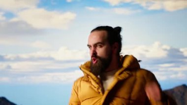 Yürüyüşçü dağın tepesine ulaşır ve başarılı bir tırmanıştan sonra zafer pozu verir. Bu da maceraya olan güveni yansıtır. Gezgin korkuları yenmenin kişisel başarısının tadını çıkarıyor. Kamera B.