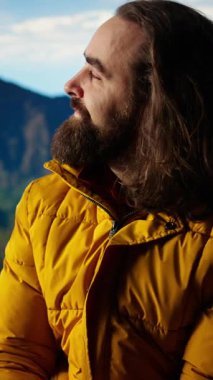 Dikey Video Maceracısı dağın zirvesinde aşırı soğuk rüzgarlarla boğuşuyor, tepenin üstünde çadırla kamp kuruyor ve güvenliğini riske atıyor. Doğa aşığı nefes kesici manzara. Kamera A.