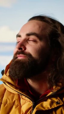 Dikey Video Maceracısı dağın zirvesinde aşırı soğuk rüzgarlarla boğuşuyor, tepenin üstünde çadırla kamp kuruyor ve güvenliğini riske atıyor. Doğa aşığı nefes kesici manzara. Kamera B.