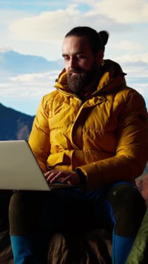 Teknolojik saplantısı olan dikey video gezgini ve doğada çalışan güçlü bir sinyal, dağın tepesine tırmanıyor ve çalışma platformuna bağlanıyor. İşkolik kişi her yerde internetin tadını çıkarıyor