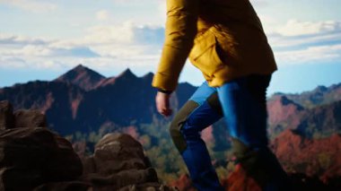 Gezgin, yüksek bir dağ sırasının kenarında tek başına duruyor, bulutlara ve çarpıcı panoramik manzaraya bakıyor. İnsanoğlu kişisel gelişim ve azim gösteriyor. Kamera A.