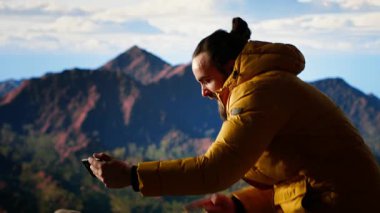 Düşüncesiz gezgin güvenlik önlemlerini göz ardı ediyor ve fotoğraf çekmeye çalışırken telefonunu düşürüyor. Yürüyüşçü, dikkatsiz ve dikkatsiz bir şekilde kendini tehlikeye atarken buldu. Kamera B.