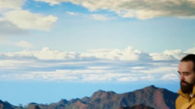 Bir dağ zirvesinde tek başına duran gezgin, sersemletici tepe manzarası, bulutlar ve sonsuz gökyüzü, maceraperest. Nefes kesici manzara kararlılığı sembolize eder. Kamera B.