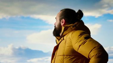 Erkek kaşif yüksek rakımlı vahşi doğanın yalnızlığını kucaklıyor, temiz hava ve manzaralı bir arka plan için dağın tepesine tırmanıyor. Doğadaki farkındalık ve rahatlama. Kamera B.