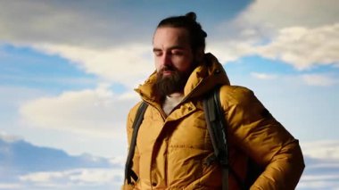 Sıcak giysiler içindeki gezgin panoramik dağ sırasına bakıyor, macera duygusunu kucaklıyor ve en nefes kesici manzaraları keşfetmekle gelen kişisel gelişimi kucaklıyor. Kamera B.