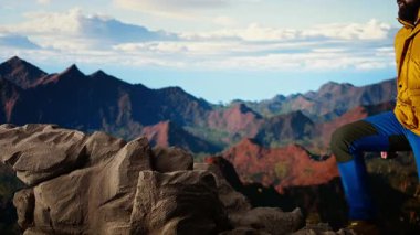 Kararlı gezgin, gökyüzünün enginliği ve engebeli zirvelerden esinlenerek destansı dağ sırasına ve manzaraya bakıyor. Açık havayı kucaklamanın mükafatı. Kamera A.