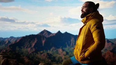 Yürüyüşçü, vahşi doğada yürümenin zorluğunu kucaklıyor, panoramik dağ manzarasının tadını çıkararak, gücün ve açık hava macerasının ödüllerini anımsatıyor. Maceraperest. Kamera A.