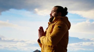 Genç kaşif dağın zirvesine ulaşıyor ve zirvede meditasyon yapıyor, sakin ve dikkatli bir şekilde zen meditasyonu yapıyor. Keyifli yürüyüşçüler doğayı özen gösterdikleri için severler. Kamera B.