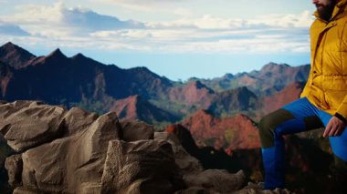 Maceraperestler önlerindeki vadiye ve dağ zirvelerine bakar. Açık arazinin özgürlüğünü hisseder. Genç adam yüksek rakımlı açık havada keşiften zevk alıyor. Kamera A.