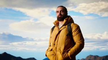 Dağın tepesinde sırt çantalı bir turist kayalara ayak basar ve başarıya tırmanmaktan zevk alır. Genç adam manzaralı vadi manzarasına, özgürlüğe bakıyor. Kamera B.