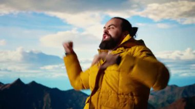 Tırmanışçılar nefes kesen bir dağ zirvesinde manzaranın keyfini çıkararak, başarılı bir yolculuktan sonra kendini mutlu ve mutlu hissederek kutluyorlar. Gururlu yürüyüşçü azmi somutlaştırır. Kamera A.