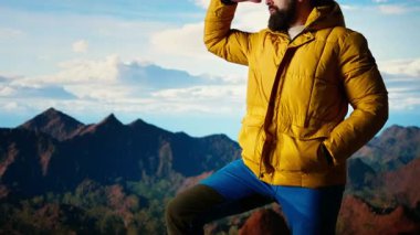 Manzaralı bir bakış açısında duran erkek kaşif dağların barışçıl güzelliğini takdir ediyor ve başarılı bir tırmanış yapıyor. Trekker yüksek irtifaya, özgürlüğe ve zihinsel açıklığa hayran. Kamera A.