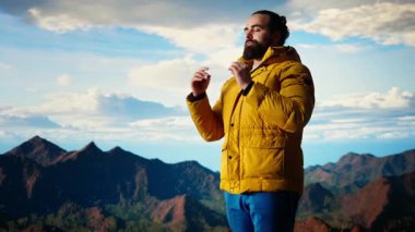 Dağın tepesinde meditasyon yapan maceraperest, tepeye başarıyla tırmanıyor ve manzaranın tadını çıkarıyor. Genç sakin zen yolcusu yürüyüş yapıyor ve meditasyon yapıyor. Kamera A.