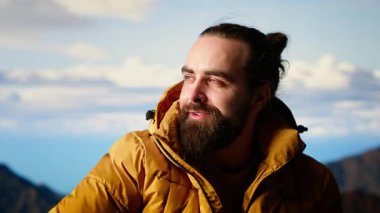 Trekker nefes kesen bir dağ sırasının tepesine tırmanıyor ve dinlenirken nefes kesici manzarada sırılsıklam oluyor. Bir doğa aşığı olarak kişisel başarısıyla gurur duyuyor. Kamera B.