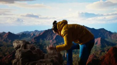 Yürüyüşçü maceracı dağın tepesindeki nefes kesici manzarayı yakalar, uzak bir dağ sırasına bakar ve vahşi doğanın güzelliğini kucaklar. Mucizeleri keşfetmenin sevinci. Kamera A.