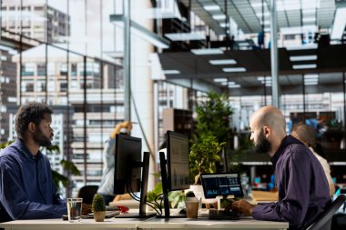 Orta Doğulu erkek analist şirkette finansal planlama ve iş stratejisi üzerinde çalışarak günlük işler yapıyor. Yönetici yardımcısı büyüme ve etkili kaynak tahsisine odaklanır.