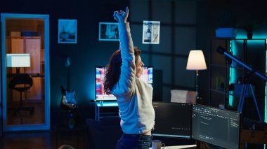 Programcı, tüm gün boyunca şirket sunucularını virüs saldırılarından koruduktan sonra uzuvlarını esnetiyor. Yorgun IT uzaktan kumandalı çalışanı, güvenlik duvarları oluşturulduktan sonra masadaki gergin kasları gevşetiyor, verileri koruyor, kamera B