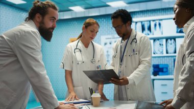 Uzmanlar röntgen sonuçlarını ve hasta bakımı stratejisini muayenehanede tartışırlar. Lisanslı doktorlardan oluşan bir ekip doğru teşhis ve etkili tedavi planları için birlikte çalışıyor. Kamera B.