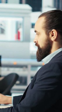 Fotovoltaik fabrikasındaki dikey video mühendisi arızalı sistemleri teşhis etmek için bilgisayar ekranı kullanıyor. Güneş panelleri bilgisayar masasında çalışan fabrika işçisi üreterek sistemin işlevsel güvenilirliğini koruyor