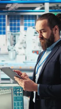 Fotovoltaik fabrikasındaki mühendislerin arızalı sistemleri teşhis etmek için tablet kullanan dikey video portresi. Güneş panelleri fabrika işçisi üretimi kesintileri azaltır ve işlevselliğini korur