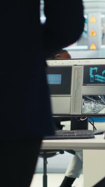 Dikey video Photovoltaics fabrikası mühendisi güneş panelleri verimliliğini artırmak için dizüstü bilgisayar kullanıyor. Güneş panelleri, sürdürülebilir güneş çözümleri kullanarak sürdürülebilir güneş çözümlerini araştıran fabrika çalışanı üretiyor