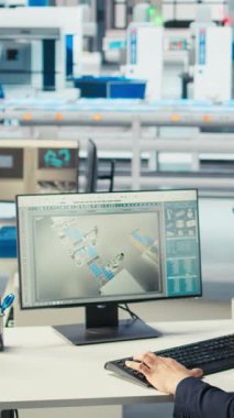 Dikey video Photovoltaics fabrika işçisi kahve içiyor, robot kollarının performansını izliyor güneş panellerini montaj hatlarına yerleştiriyor. Adam bilgisayar masasında içecekten zevk alıyor, güneş santralini inceliyor.