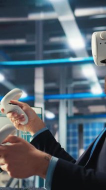 Dikey video Photovoltaics fabrika işçisi sanal gerçeklik teknolojisi kullanarak sistem performansını izliyor. Güneş panelleri enerji üretimi ve verimliliğini izlemek için VR kulaklık kullanan fabrika çalışanı üretiyor.
